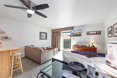 a living room with a couch and a ceiling fan at Cozy Studio w/ Partial Lake view #223 at Donner Lake Village in Truckee