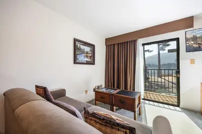 a living room with a couch and a window at Cozy Studio w/ Partial Lake view #223 at Donner Lake Village in Truckee