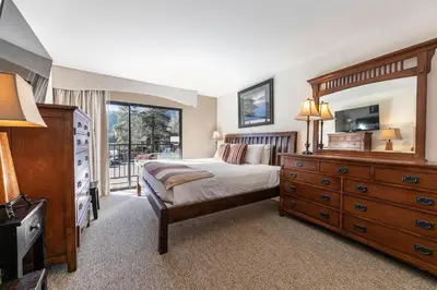 a bedroom with a bed and a dresser and a television at Spacious 1BR Condo w/Partial Lake View #222 at Donner Lake Village in Truckee