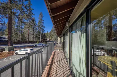 a balcony of a building with cars parked on the street at Spacious 1BR Condo w/Partial Lake View #222 at Donner Lake Village in Truckee