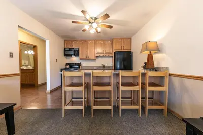 a kitchen with a bar with chairs and a ceiling fan at Spacious 1BR Condo w/Partial Lake View #222 at Donner Lake Village in Truckee