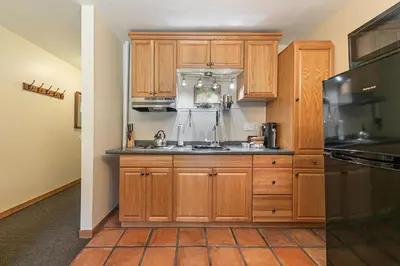 a kitchen with wooden cabinets and a sink at Cozy Studio wKitchen #217 at Donner Lake Village in Truckee