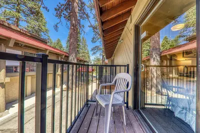 a white chair sitting on the porch of a house at Cozy Studio wKitchen #217 at Donner Lake Village in Truckee