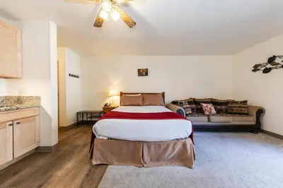 a bedroom with a large bed and a couch at Studio w/Kitchen 2nd Floor #213 at Donner Lake Village in Truckee
