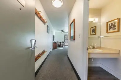 a hallway with a bathroom with a sink and a mirror at Homey 1st Floor Studio #135 at Donner Lake Village in Truckee