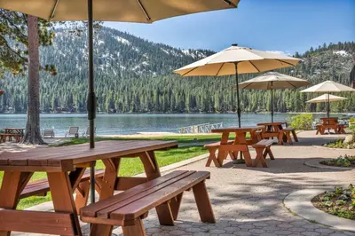a group of picnic tables with umbrellas and a lake at Spacious 1BR Condo w/ Lake View #136 at Donner Lake Village in Truckee