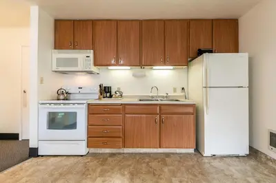 a kitchen with a white refrigerator and wooden cabinets at Spacious 1BR Condo w/ Lake View #136 at Donner Lake Village in Truckee
