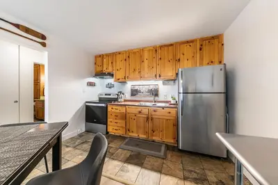 a kitchen with wooden cabinets and a stainless steel refrigerator at Inviting King Deluxe 1 BR Condo W/Lake view #141 at Donner Lake Village in Truckee