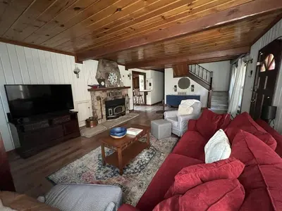 a living room with a red couch and a fireplace at Twain Harte Lake, pool/hot tub, by skiing/Yosemite in Twain Harte