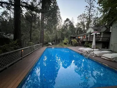a large blue swimming pool next to a house at Twain Harte Lake, pool/hot tub, by skiing/Yosemite in Twain Harte