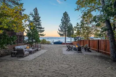 a patio with chairs and tables on the beach at Waves End Lakefront - 3BR Tahoe Vista w Private Sandy Beach, Walk to Town! in Tahoe Vista