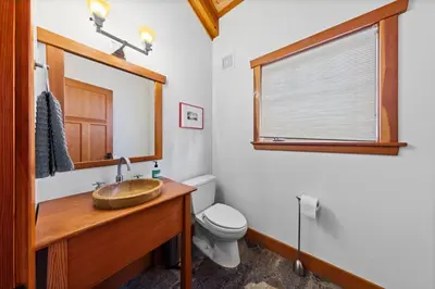 a bathroom with a wooden sink and a toilet at Copperleaf Lodge by Tahoe Getaways - Updated 5BR Alpine Meadows Chalet w Private Hot Tub, Ski Shuttle! in Alpine Meadows