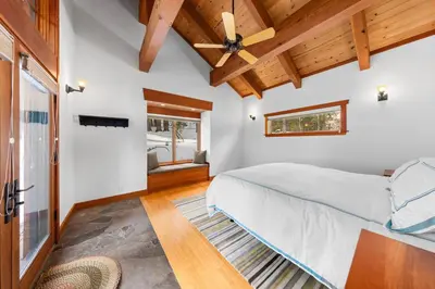 a bedroom with a bed and a ceiling fan at Copperleaf Lodge by Tahoe Getaways - Updated 5BR Alpine Meadows Chalet w Private Hot Tub, Ski Shuttle! in Alpine Meadows