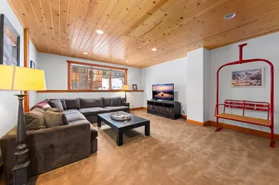 a living room with a couch and a tv at Copperleaf Lodge by Tahoe Getaways - Updated 5BR Alpine Meadows Chalet w Private Hot Tub, Ski Shuttle! in Alpine Meadows