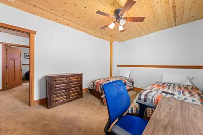 a bedroom with a bed and a ceiling fan at Copperleaf Lodge by Tahoe Getaways - Updated 5BR Alpine Meadows Chalet w Private Hot Tub, Ski Shuttle! in Alpine Meadows