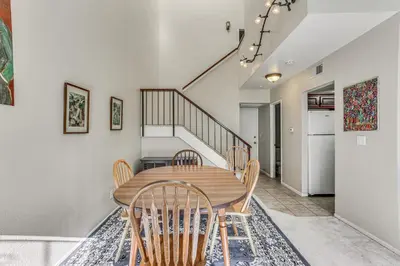 a dining room with a wooden table and chairs at Spacious Downtown Fresno Townhome Walk to UCSF in Fresno
