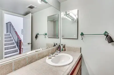 a bathroom with a sink and a mirror at Spacious Downtown Fresno Townhome Walk to UCSF in Fresno