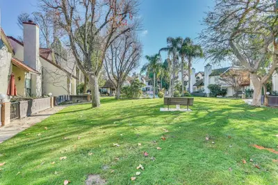 a park with a bench in the grass at Spacious Downtown Fresno Townhome Walk to UCSF in Fresno