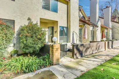 a house with a fence in front of it at Spacious Downtown Fresno Townhome Walk to UCSF in Fresno