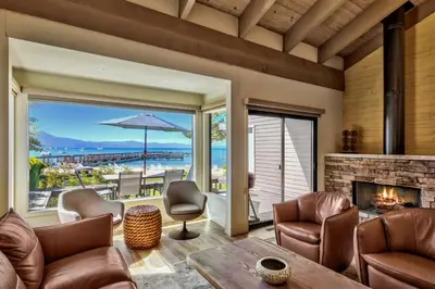 a living room with a fireplace and a view of the ocean at Lakeland Village 620 - Beachfront Bliss in South Lake Tahoe