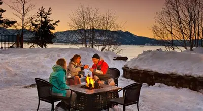 a group of people sitting around a fire in the snow at Lakeland Village 620 - Beachfront Bliss in South Lake Tahoe
