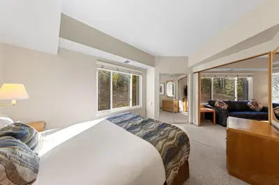 a bedroom with a large bed and a living room at Palisades Tahoe Lodge Rentals One Bedroom #120 in Olympic Valley