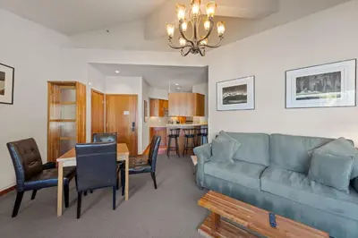 a living room with a couch and a dining room at Palisades Tahoe Lodge Rentals Premium One Bedroom #321 in Olympic Valley