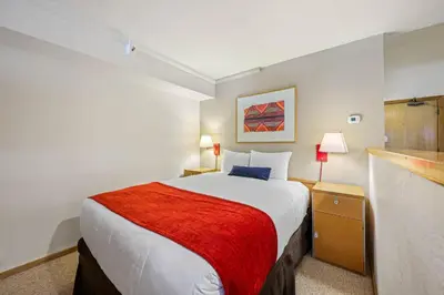 a hotel room with a bed with a red blanket at Palisades Tahoe Lodge Rentals Studio Loft #307 in Olympic Valley
