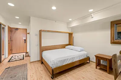 a bedroom with a bed and a table at Palisades Tahoe Lodge Rentals Studio Loft #315 in Olympic Valley