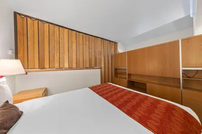 a bedroom with a white bed and wooden cabinets at Palisades Tahoe Lodge Rentals Studio Loft #317 in Olympic Valley