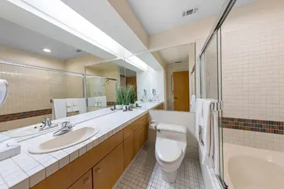 a bathroom with two sinks and a toilet and a tub at Palisades Tahoe Lodge Rentals Studio Loft #317 in Olympic Valley