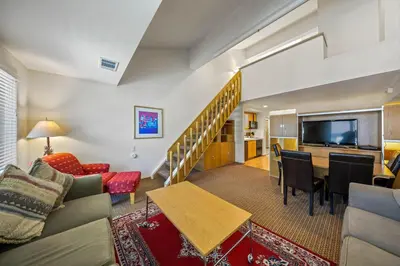 a living room with a couch a table and a television at Palisades Tahoe Lodge Rentals Studio Loft #305 in Olympic Valley