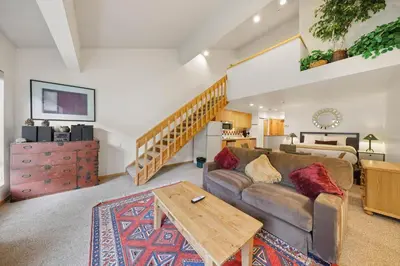 a living room with a couch and a table at Palisades Tahoe Lodge Rentals Studio Loft #345 in Olympic Valley