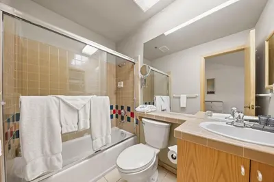 a bathroom with a toilet and a sink and a tub at Palisades Tahoe Lodge Rentals Studio Loft #345 in Olympic Valley