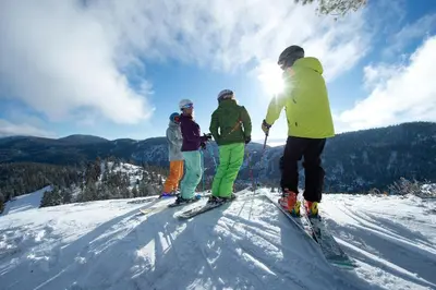 a group of people standing on top of a ski slope at Palisades Tahoe Lodge Rentals Studio Loft #331 in Olympic Valley