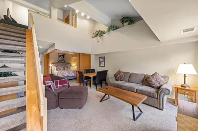 a living room with a couch and a table at Palisades Tahoe Lodge Rentals Studio Loft #331 in Olympic Valley