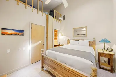 a bedroom with a large bed and a staircase at Studio Loft #348 in Olympic Valley
