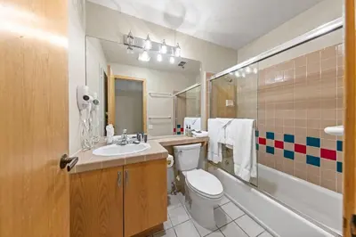 a bathroom with a toilet and a sink and a tub at Palisades Tahoe Lodge Rentals Studio Loft #349 in Olympic Valley