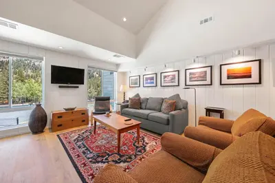 a living room with a couch and a tv at Palisades Tahoe Lodge Rentals Premium Studio Loft #333 in Olympic Valley