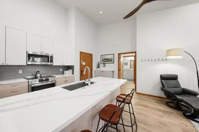 a kitchen with a large white counter and two chairs at Palisades Tahoe Lodge Rentals Premium Two Bedroom #805 in Olympic Valley
