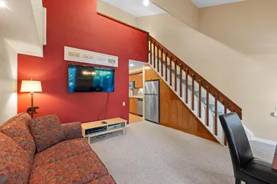 a living room with a couch and a kitchen at Palisades Tahoe Lodge Rentals Premium Studio Loft #313 in Olympic Valley