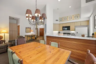 a dining room and living room with a wooden table at Palisades Tahoe Lodge Rentals Two Bedroom #422 in Olympic Valley