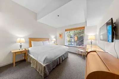 a bedroom with a large bed and a window at Palisades Tahoe Lodge Rentals Two Bedroom #521 in Olympic Valley