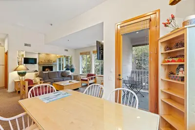 a kitchen and living room with a table and chairs at Palisades Tahoe Lodge Rentals Two Bedroom #521 in Olympic Valley