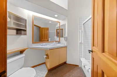 a bathroom with a sink and a toilet and a mirror at Palisades Tahoe Lodge Rentals Two Bedroom #521 in Olympic Valley