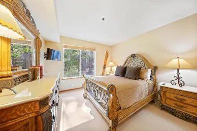 a bedroom with a bed and a desk and a window at Palisades Tahoe Lodge Rentals Two Bedroom #512 in Olympic Valley