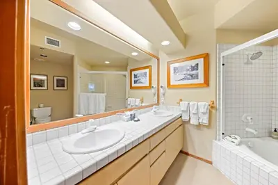 a bathroom with two sinks and a large mirror at Palisades Tahoe Lodge Rentals Two Bedroom #512 in Olympic Valley