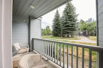 a balcony with two chairs and a view of a yard at Palisades Tahoe Lodge Rentals Two Bedroom #703 in Olympic Valley