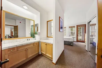 a bathroom with two sinks and a large mirror at Palisades Tahoe Lodge Rentals Two Bedroom #703 in Olympic Valley