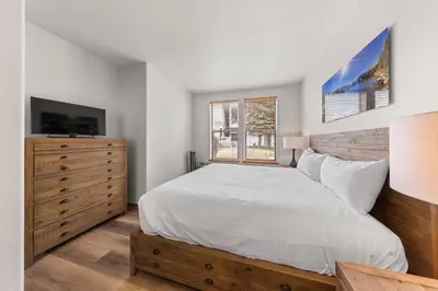 a bedroom with a bed and a tv and a dresser at Palisades Tahoe Lodge Rentals Two Bedroom #705 in Olympic Valley
